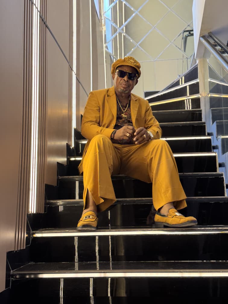 King Duke Melody wearing a coordinated mustard suit and matching shoes